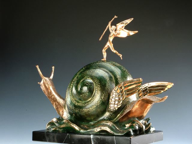 Cette image représente une sculpture de l'artiste Salvador Dalí intitulée "Snail and the Angel". Réalisée en bronze à la cire perdue, de couleurs vertes et dorée, on y retrouve un escargot avec des ailes et un ange triomphant sur sa coquille. Elle mesure 44 cm et est exposée à la Galerie Montmartre à Paris, France.